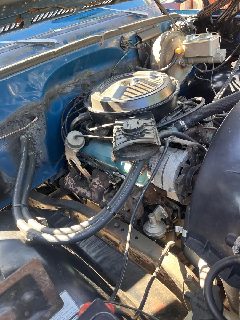 The engine bay of a classic pickup, inspected before its buyer committed — Riverside, CA