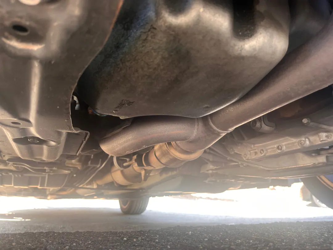 Exhaust and underbody on the same inspection — rust and impact damage both show up down here — Riverside, CA