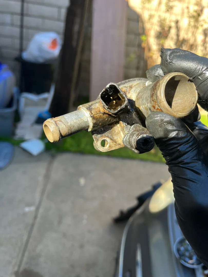 Thermostat housing off in the customer's driveway during a cooling job in Riverside, CA